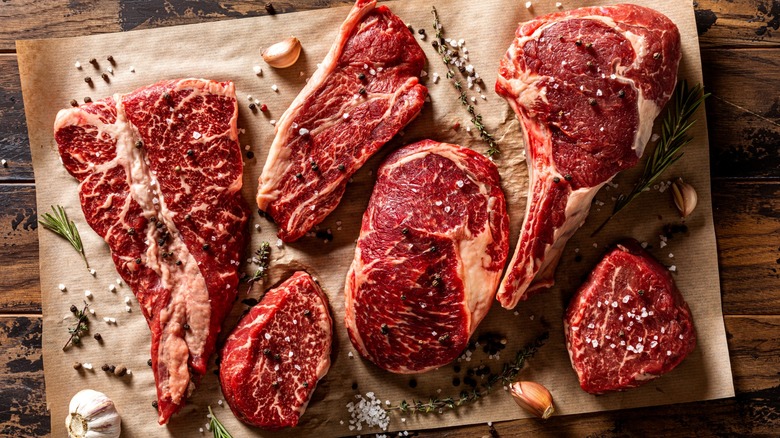 Various raw cuts of steak on butcher paper