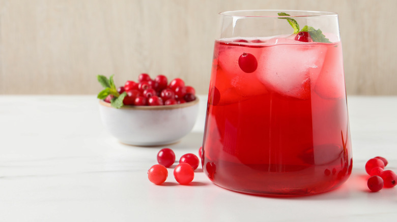 A glass of cranberry juice and fresh cranberries