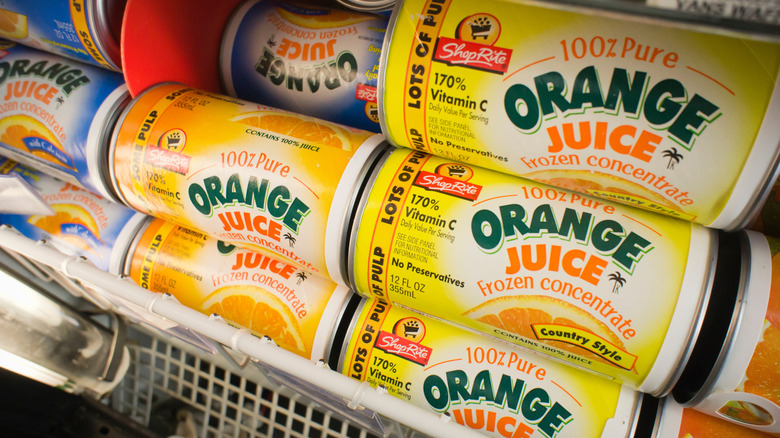 Cans of frozen orange juice in a freezer