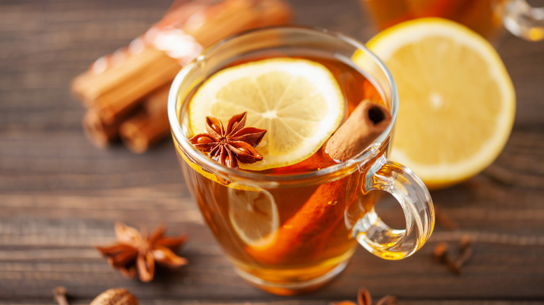 Whiskey cocktail in handle cup with anise, lemon, cinnamon stick