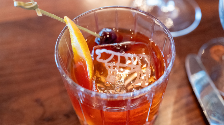 Whiskey cocktail with an orange and cherry garnish