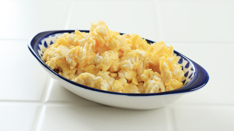 Scrambled eggs served in a small oval white and blue bowl