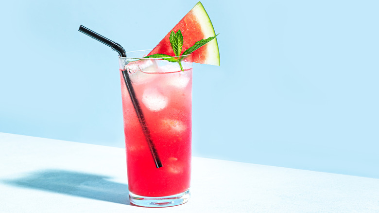 A watermelon drink garnished with mint and a watermelon wedge.