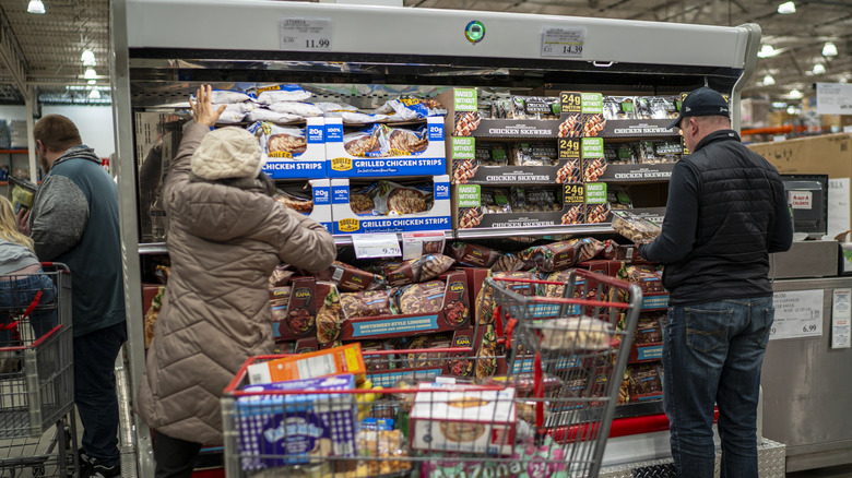 Costco shoppers grabbing items from the meat section