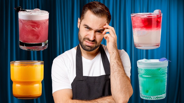 Bartender in an apron thinking with four cocktails surrounding him