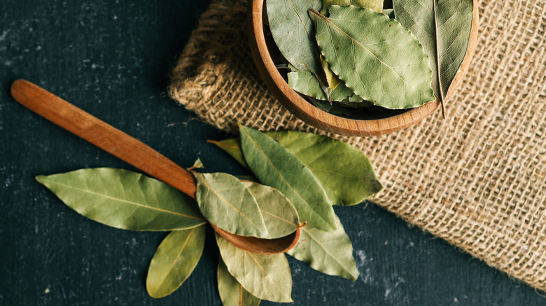 Dried bay leaves in a wooden bowl with a spoon