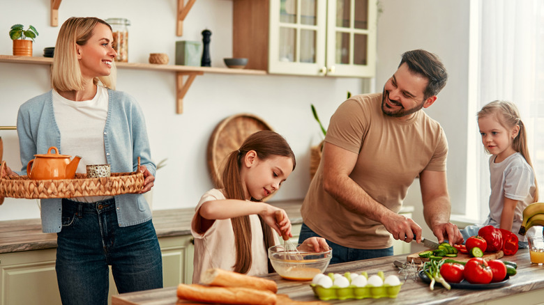 A family is cooking together in a bright kitchen