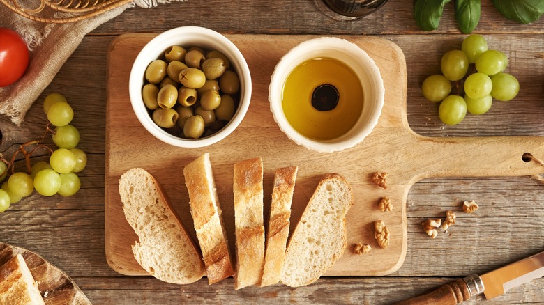 Balsamic vinegar with olive oil, Italian ciabatta bread, grapes, basil and tomatoes, top view
