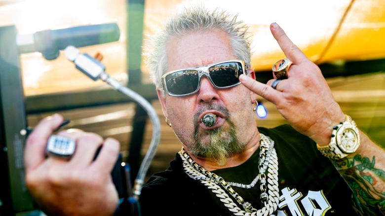 Guy Fieri posing for photograph with cigar in mouth
