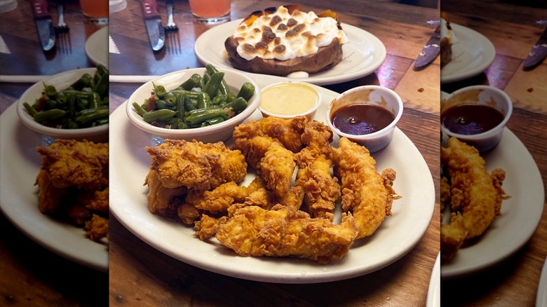 Texas Roadhouse chicken critters on white plate with green beans and two sauces