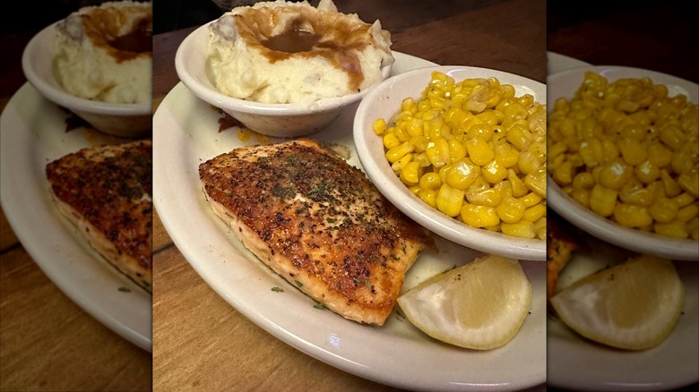 Texas Roadhouse grilled salmon on white plate with corn and lemon and mashed potatoes with gravy