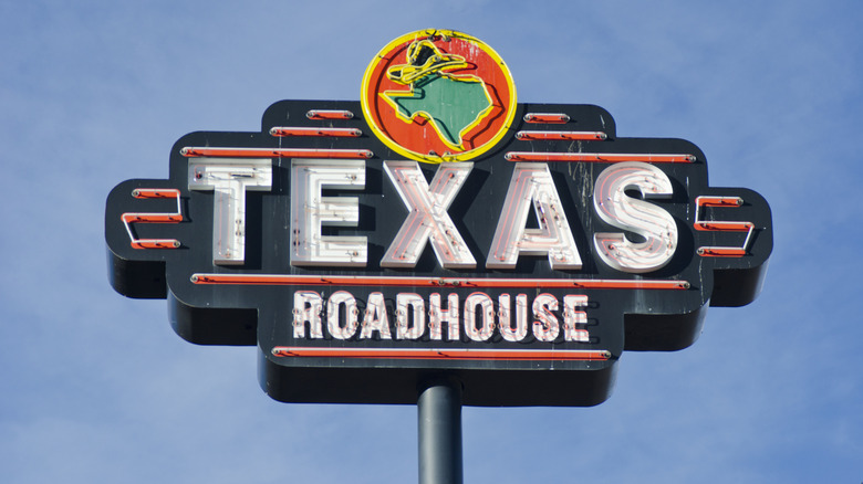 Tall exterior Texas Roadhouse sign against blue sky