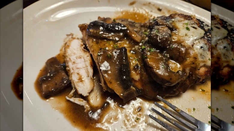 Texas Roadhouse portobello mushroom chicken sliced on white plate with fork