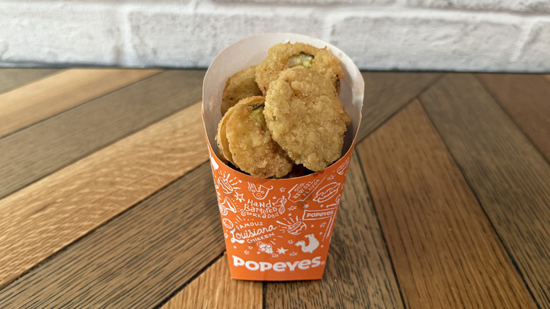A Popeyes cup filled with Fried Pickle chips