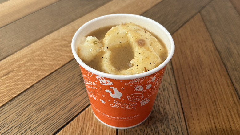 A cup filled with Mashed Potatoes with Cajun Gravy