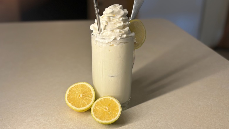 Garnished whipped lemonade with straw on kitchen counter