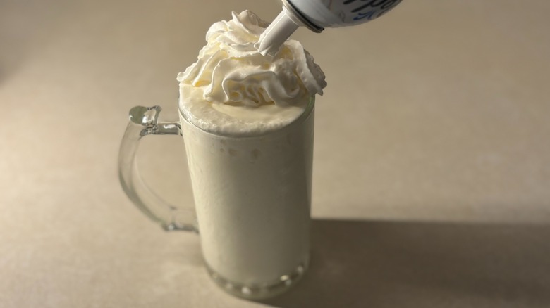 Whipped cream being added to whipped lemonade drink