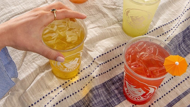Hand reaching for cup of Wendy's lemonade