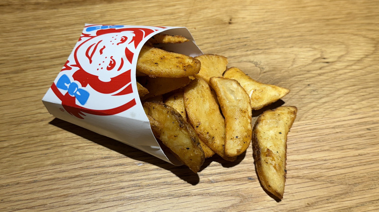 A cup of Seasoned Potatoes on a table