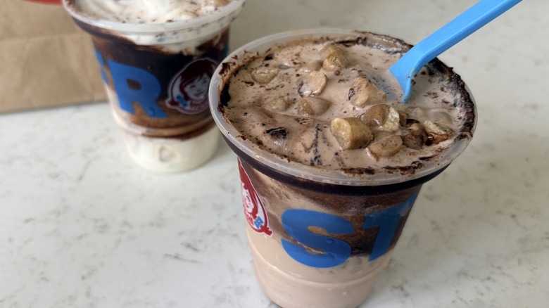 An open cup of Wendy's Cookie Dough Frosty Fusion in chocolate