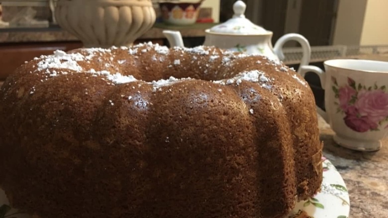 A white almond bundt cake topped with powdered sugar