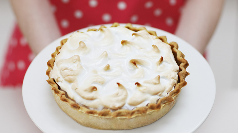 A peanut butter pie with crinkled crust and meringue topping