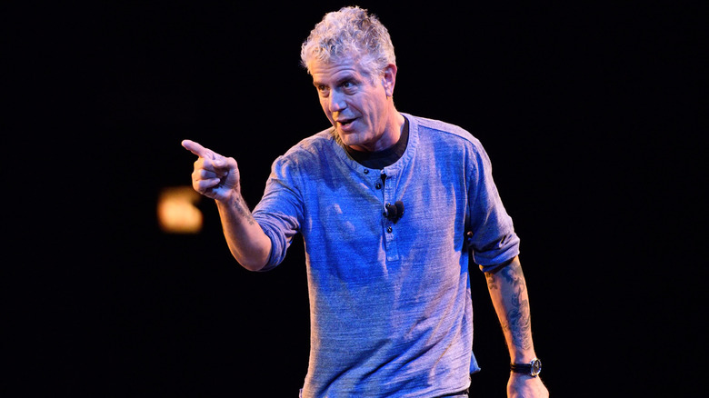 Anthony Bourdain perfoming on stage, pointing at the crowd