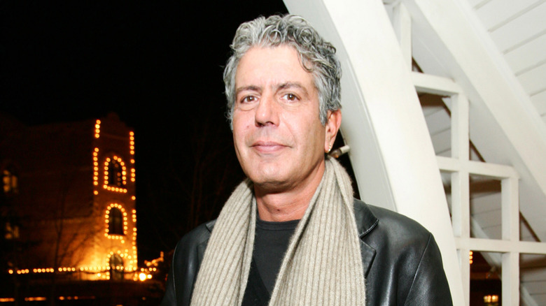 Anthony Bourdain standing in front of a window