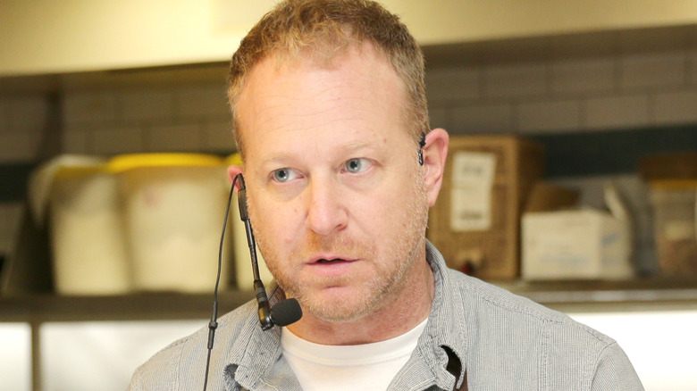Andy Ricker talking into mic while cooking
