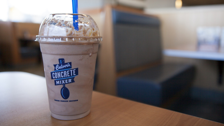 A cup of Culver's Concrete Mixer ice cream dessert sitting on a dining room table.