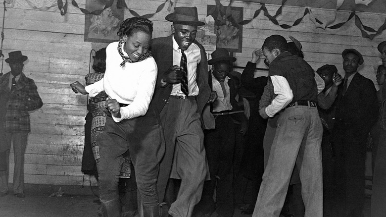 A well dressed couple dancing at a juke joint