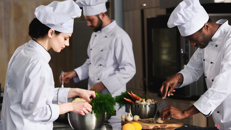 Three chefs working in a commercial kitchen