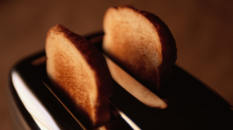 two slices of toast popping out of a silver toaster