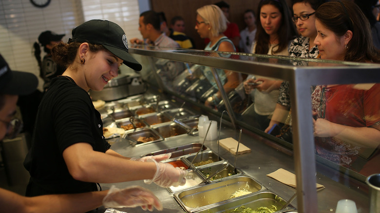 Chipotle restaurant workers filling orders for store customers.