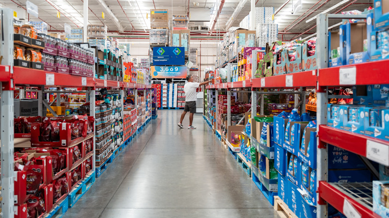 Man reaches for product at far end of long and wide aisle at Sam's Club