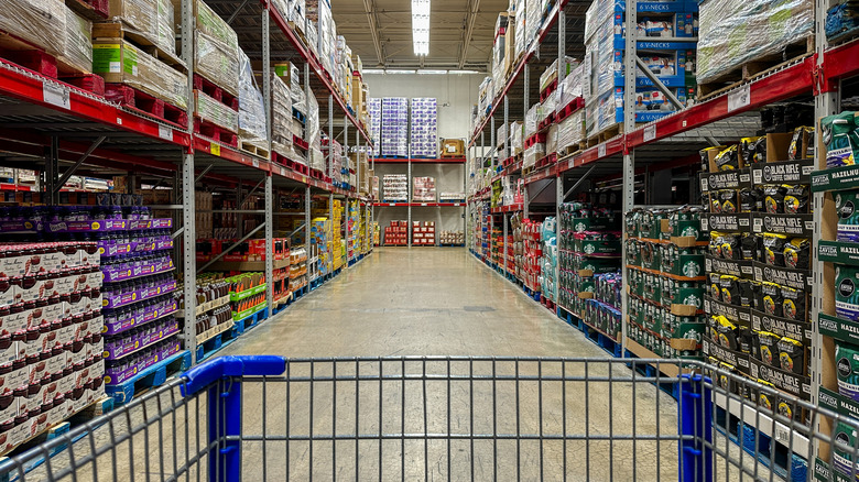 Point of view from shopping cart in Sam's Club aisle stocked high with products in bulk