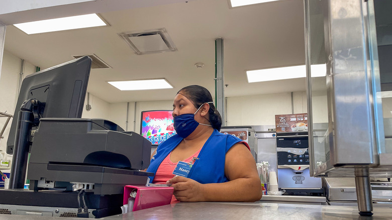 Sam's Club employee stands behind computer at counter in cafe