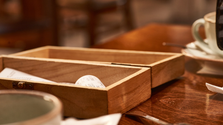 receipt in wooden box on table