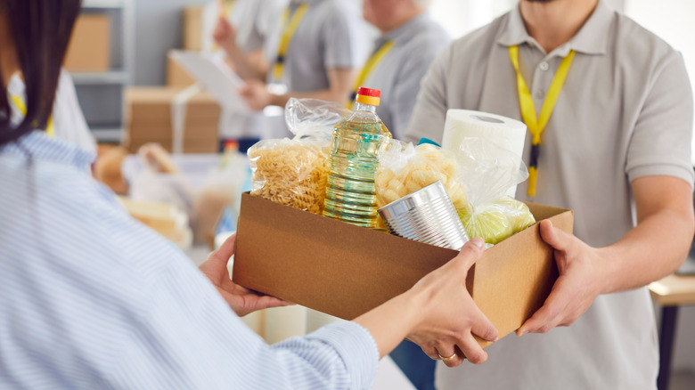 Someone donating food to a food drive.
