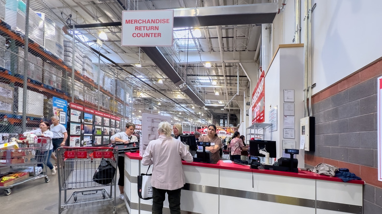 Customers stand at the Costco return counter.