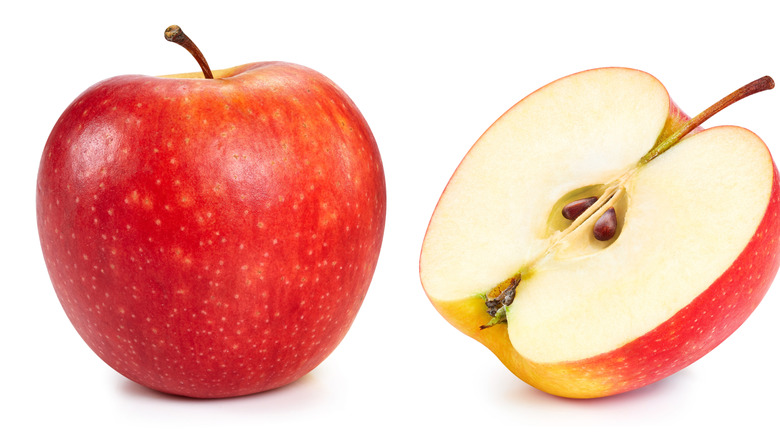 A whole apple and a sliced apple on a white background
