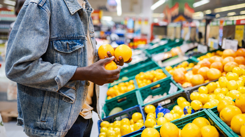 A man buying lemons in a supermarket