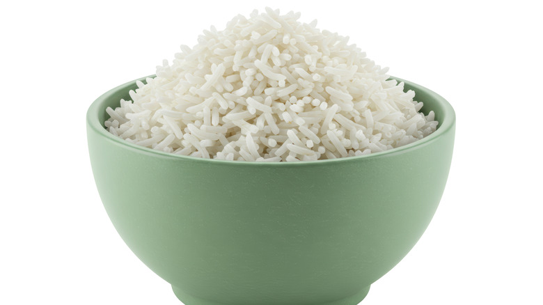 A green bowl of white rice on a white background