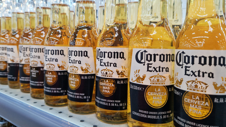 Bottles of Corona sitting on a shelf.