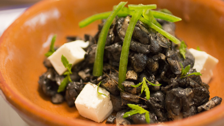 A fancy plate of sautéed huitlacoche with cheese cubes and jalapeño peppers