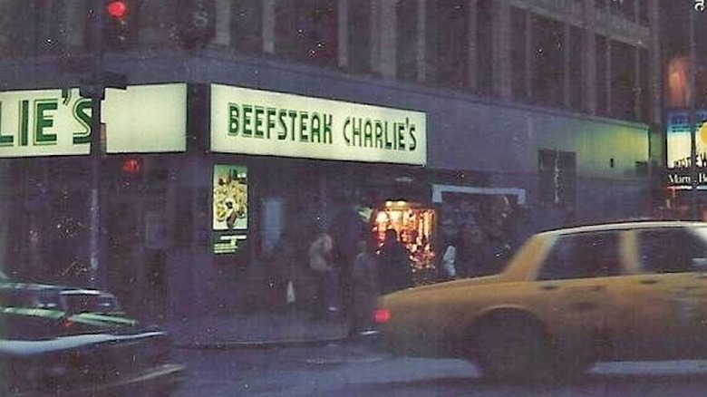Street view of the original Beefsteak Charlies with a taxi going past it