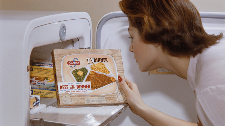woman taking Swanson tv dinner from freezer