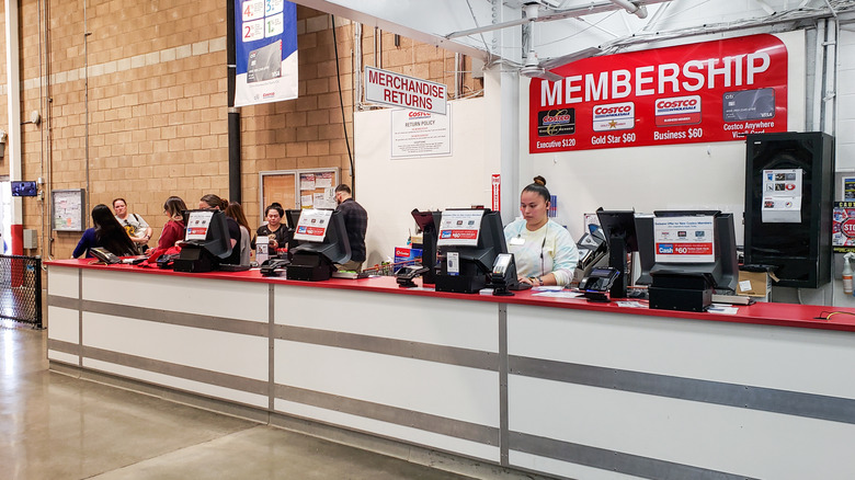 Employees working behind the merchandise return desk at Costco.