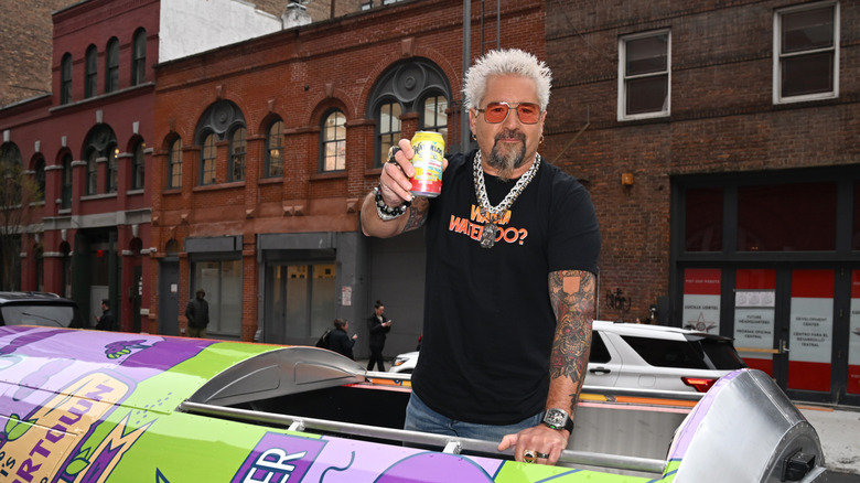 Celebrity chef Guy Fieri holding drink can