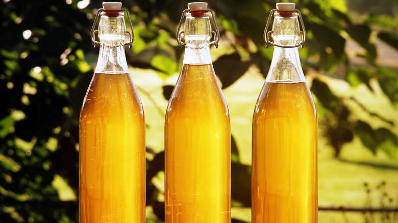 Three glass bottles full of mead